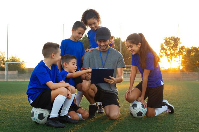 Football Trainer Teaching Kids